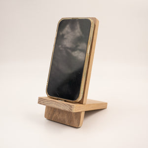 White oak phone holder holding an iPhone 14 Pro