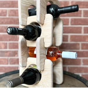 Puzzle piece wine rack holding four wine bottles in front of a brick wall