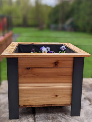 Cedar garden planter box with black corner posts and flowers