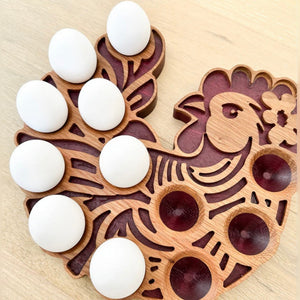 Rooster shaped wooden egg display holding white eggs on a light wood table